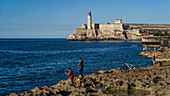 Fishing along the coast with Morro Castle in the distance; Havana, Cuba