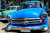 Vintage cars parked at a curb; Havana, Cuba