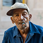 Porträt eines älteren kubanischen Mannes, der eine Zigarre raucht; Havanna, Kuba