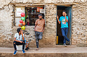 Junge äthiopische Männer vor einem Geschäft; Gondar, Amhara-Region, Äthiopien