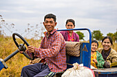 Family riding together in truck through farm fields; Taungyii, Shan State, Myanmar