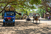 Various modes of transport on a street with a truck, motorcycle, horse and carriage; Bagan, Mandalay Region, Myanmar