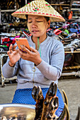 Frau mit ihrem Smartphone auf dem Markt; Lashio, Shan-Staat, Myanmar