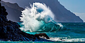 Large ocean wave crashes into rock along the Na Pali Coast; Kauai, Hawaii, United States of America