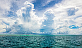 Turquoise water of the Pacific Ocean with a cloud-filled big sky overhead; Malolo Island, Fiji