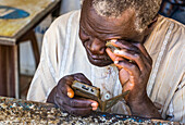 Sudanese, der ein Mobiltelefon repariert; Kerma, Nordstaat, Sudan