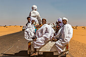 Sudanese men riding in the back of a Toyota pick-up truck; Old Dongola, Northern State, Sudan