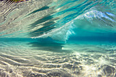 Surf crashes over a sandy bottom off the island of Maui; Maui, Hawaii, United States of America