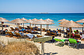 Ferienanlage mit Stühlen und Unterstand am Strand von Plaka am Mittelmeer; Insel Naxos, Kykladen, Griechenland