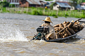 A man drives a motorboat in Inle Lake to transport goods; Yawngshwe, Shan State, Myanmar