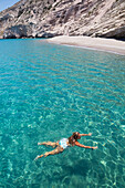 Touristin beim Schwimmen im klaren, türkisfarbenen Wasser der Bucht von Galazia Nera; Insel Polyaigos, Kykladen, Griechenland