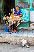 Eine ältere Frau flechtet einen Korb; Sidetapa, Bali, Indonesien