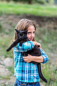 Junges Mädchen mit Farmkatze; Armstrong, British Columbia, Kanada