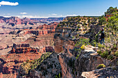 Tourist in der Nähe des Randes, der die Aussicht auf den Grand Canyon vom Mohave Point genießt, mit einem Blick auf den Colorado River und den Powell Point in der Ferne, South Rim; Arizona, Vereinigte Staaten von Amerika