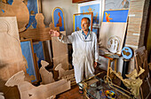 Artisan showing his handiwork of wood carvings and paintings; Venice, Italy