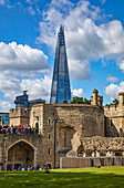 Tourists at the Tower of London with the Shard commerical skyscraper in the background; London, England