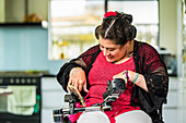 Maori woman with Cerebral Palsy in a wheelchair using a smart phone; Wellington, New Zealand