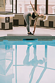 Woman working out on a mat beside a pool; Wellington, New Zealand