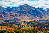 The Chugach valley in autumn colours with a snow-covered mountain top in the background; Alaska, United States of America