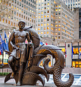 Skulptur eines barfüßigen jungen Mannes ohne Hemd, mit Flaggen und Wolkenkratzern im Hintergrund; New York City, New York, Vereinigte Staaten von Amerika
