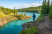 Eine Frau steht oberhalb des Miles Canyon und blickt auf den Yukon River; Whitehorse, Yukon, Kanada