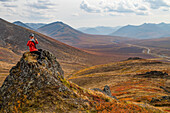 Woman exploring the mountains along the Dempster Highway during autumn in the autumn; Yukon, Canada