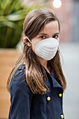 Junges Mädchen trägt eine Schutzmaske zum Schutz vor COVID-19 während der Coronavirus-Weltpandemie; Toronto, Ontario, Kanada