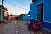 Motorrad mit Beiwagen, geparkt neben einem bunten Gebäude auf einer Kopfsteinpflasterstraße, Trinidad, Kuba, Westindien, Karibik
