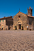 Church of Santa Maria Assunta on cobblestone street, Monteriggioni, Chianti, Province of Siena, Tuscany, Italy