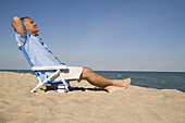 Mann entspannt sich am Strand, Lake Michigan, USA