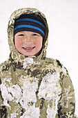 Kleiner Junge beim Spielen im Schnee