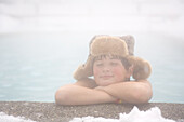Kleiner Junge beim Entspannen im Freibad im Skigebiet