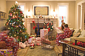 Kinder beim Öffnen der Geschenke am Weihnachtsmorgen