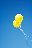 Two Yellow Balloons in Sky