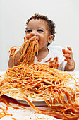 Junge isst Spaghetti mit den Händen