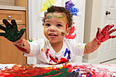 Kleiner Junge malt mit Fingerfarben