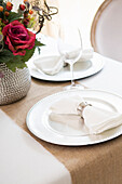 Elegant table setting at wedding event with plate charger and napkin
