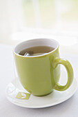 Cup of Tea in Green Mug with Saucer, Studio Shot