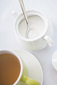 Zuckerdose mit Löffel und Teetasse in grüner Tasse, Studio Shot