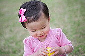 Toddler Girl Smiling while she Opens an Easter Egg