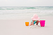 Mädchen im Kleinkindalter spielt mit Schaufel und Eimer im Sand am Strand, Destin, Florida, USA