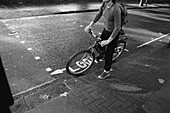 Frau auf Straße mit Fahrrad, London, England