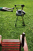 Boy Lying Down Next to Lawnmower