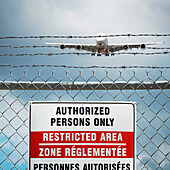 Jumbo Jet and Restricted Area Sign on Chain Link Fence with Barbed Wire, Pearson International Airport, Toronto, Ontario, Canada