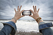 Frau beim Fotografieren des drohenden Hurrikans Sandy, Point Pleasant, New Jersey, USA