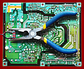 pair of needle nose pliers on electronic circuit board