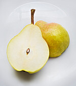 Close-up of pear halves on a white plate, studio shot on white background
