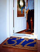 Mann öffnet Haustür mit Willkommensmatte mit Hausnummer und Kranz an der Tür, Toronto, Ontario, Kanada
