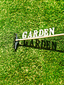 Gartenharke mit dem Text Garden auf Gras