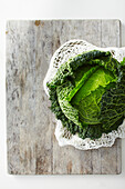 Overhead View of Savoy Cabbage on Wooden Cutting Board, Studio Shot